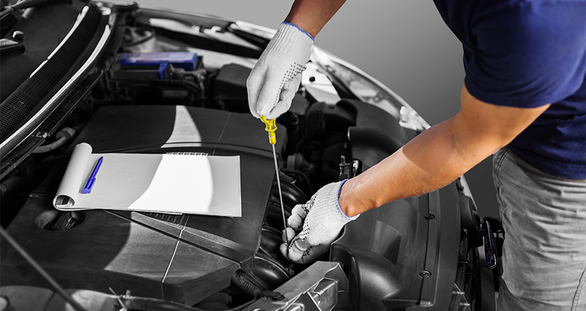 Technician checking oil level as part of an MOT test